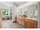 Light and bright bathroom features double sinks, wood cabinets, and a window to the backyard at 7999 Centrebridge Dr, Niwot, CO 80503