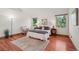 Bright main bedroom boasts hardwood floors, natural light, sitting area, and two windows with views of the outdoors at 7999 Centrebridge Dr, Niwot, CO 80503