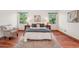Serene main bedroom featuring hardwood floors, natural light, a sitting area, and two windows with nature views at 7999 Centrebridge Dr, Niwot, CO 80503