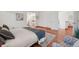 Bright main bedroom features a comfortable bed, wood floors, and a view into the bathroom at 7999 Centrebridge Dr, Niwot, CO 80503