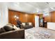 Finished basement area with comfortable seating, wood paneling, and ample space at 6981 Zuni St, Denver, CO 80221