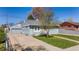 Gray home featuring a detached garage and a well-maintained front yard at 6981 Zuni St, Denver, CO 80221