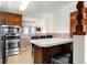 Efficient kitchen with stainless steel appliances, breakfast bar, and wooden cabinets at 6981 Zuni St, Denver, CO 80221