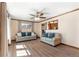 Bright living room with hardwood floors, ample seating, and a view into the kitchen at 6981 Zuni St, Denver, CO 80221