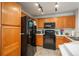 Updated kitchen featuring oak cabinets, black appliances, and a modern track lighting system at 8707 E Florida Ave # 510, Denver, CO 80247
