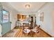 Bright dining area with hardwood floors and a view into the kitchen and entryway at 1201 Poplar St, Denver, CO 80220