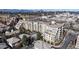 Stunning aerial view showcasing elegant condos with balconies, pool area, street view and the city skyline in the distance at 2500 E Cherry Creek South Dr # 213, Denver, CO 80209