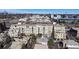 Beautiful aerial view of multi-story condos surrounded by lush greenery and a pool with the city skyline in the background at 2500 E Cherry Creek South Dr # 213, Denver, CO 80209