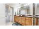 Bathroom features double sinks, granite counters, wood cabinets and decorative mirrors at 2500 E Cherry Creek South Dr # 213, Denver, CO 80209