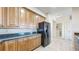 Well-equipped kitchen with hardwood cabinets and sleek black appliances, adjoining a laundry room at 2500 E Cherry Creek South Dr # 213, Denver, CO 80209
