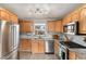 Well-equipped kitchen featuring stainless steel appliances, granite countertops, and wooden cabinets at 2960 Grape St, Denver, CO 80207