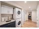 Basement laundry room with a stacked washer/dryer and sleek cabinets at 2960 Grape St, Denver, CO 80207