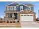 Inviting two-story home with stone accents, a covered porch, and a well-manicured front yard at 23913 E Minnow Cir, Aurora, CO 80016