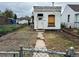 Small white brick home in need of repair, with a small yard and chain link fence at 1037 Hazel Ct, Denver, CO 80204