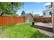 Backyard with wood deck, lawn, fenced perimeter, and detached garage at 1366 S Vine St, Denver, CO 80210