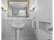 Charming powder room featuring a pedestal sink, elegant lighting fixtures, and a decorative mirror at 1366 S Vine St, Denver, CO 80210