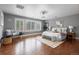 Spacious bedroom with hardwood floors, white bedding, bench seat, and bright windows with white shutters at 1366 S Vine St, Denver, CO 80210