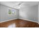 Bedroom featuring hardwood floors, a ceiling fan, a large window, and neutral walls at 1366 S Vine St, Denver, CO 80210