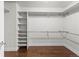 Walk-in closet featuring hardwood floors, white walls, and built-in white shelves and metal hanging bars at 1366 S Vine St, Denver, CO 80210