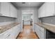 Well-lit kitchen galley featuring white cabinets and a view into additional kitchen at 1366 S Vine St, Denver, CO 80210