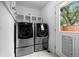 Convenient laundry room equipped with modern washer and dryer units, storage shelves, and exterior access at 1366 S Vine St, Denver, CO 80210