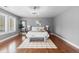 Well-lit primary bedroom features hardwood floors, soft lighting, and large windows with white shutters at 1366 S Vine St, Denver, CO 80210