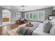 Bright primary bedroom features hardwood floors, gray walls, bright windows, and an ensuite bathroom at 1366 S Vine St, Denver, CO 80210