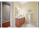 Bright bathroom featuring a vanity, decorative mirror, and neutral tile flooring at 4378 Fell Mist Way, Castle Rock, CO 80109