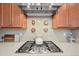 Modern kitchen featuring a stainless steel gas cooktop, neutral backsplash, and stylish light wood cabinets at 4378 Fell Mist Way, Castle Rock, CO 80109