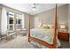 Serene primary bedroom with a four poster bed, windows, and neutral color palette at 4378 Fell Mist Way, Castle Rock, CO 80109