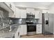Kitchen showcasing stainless steel appliances, granite countertops, and white cabinetry at 875 E 78Th Ave # 52, Denver, CO 80229