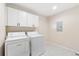 Laundry room featuring white cabinets and a washer and dryer at 875 E 78Th Ave # 52, Denver, CO 80229