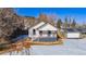 House aerial view, snowy yard, and mountain background at 202 Lower Glenway St, Palmer Lake, CO 80133