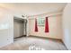 The bedroom is bright, with fresh white walls, neutral carpeting, and a window with red curtains at 7755 E Quincy Ave # 104A6, Denver, CO 80237