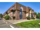 Charming building featuring brick and wood trim, complemented by well-maintained landscaping at 7755 E Quincy Ave # 104A6, Denver, CO 80237