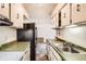 Functional kitchen features a black refrigerator, a stainless steel sink, and overhead cabinetry at 7755 E Quincy Ave # 104A6, Denver, CO 80237