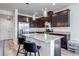 This is a lovely shot of the kitchen, featuring dark wood cabinetry, stainless steel appliances, and a speckled granite island at 1841 S Dunkirk St # 101, Aurora, CO 80017