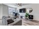 This cozy living room boasts wood floors, a comfortable couch, a TV, and a ceiling fan, perfect for relaxation and entertainment at 1841 S Dunkirk St # 101, Aurora, CO 80017