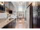 Efficient kitchen with stainless steel appliances, dark cabinetry, granite counters, and seamless access to the dining area at 1375 N Williams St # 206, Denver, CO 80218