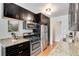 Functional kitchen showcases stainless steel appliances, black cabinetry, granite countertops, and a gas range at 1375 N Williams St # 206, Denver, CO 80218