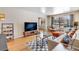 Cozy living room with a sofa, large-screen TV, decorative shelving unit, and windows overlooking the neighborhood at 1375 N Williams St # 206, Denver, CO 80218