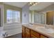 Bathroom featuring double sinks, a large mirror, and a tub at 2253 E 100Th Pl, Thornton, CO 80229