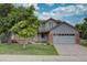 Two-story home featuring a lush front lawn, a covered porch, brick accents, and an attached two-car garage at 2253 E 100Th Pl, Thornton, CO 80229