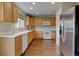 Functional kitchen with wooden cabinets, white appliances, and hardwood flooring, providing a cozy and efficient cooking space at 2253 E 100Th Pl, Thornton, CO 80229