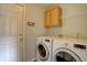 Convenient laundry room with washer, dryer, cabinets, and storage shelf at 2253 E 100Th Pl, Thornton, CO 80229