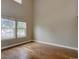 Bright living room featuring hardwood floors, tall ceilings, and large windows, creating a spacious and airy atmosphere at 2253 E 100Th Pl, Thornton, CO 80229