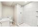 Modern bathroom featuring a tiled walk-in shower, a white vanity, and neutral-toned flooring for a clean aesthetic at 235 S 8Th Ave, Brighton, CO 80601