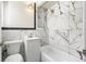 Modern bathroom showcasing marble walls, sleek fixtures, and a bathtub at 235 S 8Th Ave, Brighton, CO 80601