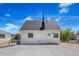 Rear exterior view of home showing white siding and access door with concrete driveway at 235 S 8Th Ave, Brighton, CO 80601