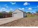 View of detached garage with a manual sliding door, side door, and partial driveway at 235 S 8Th Ave, Brighton, CO 80601